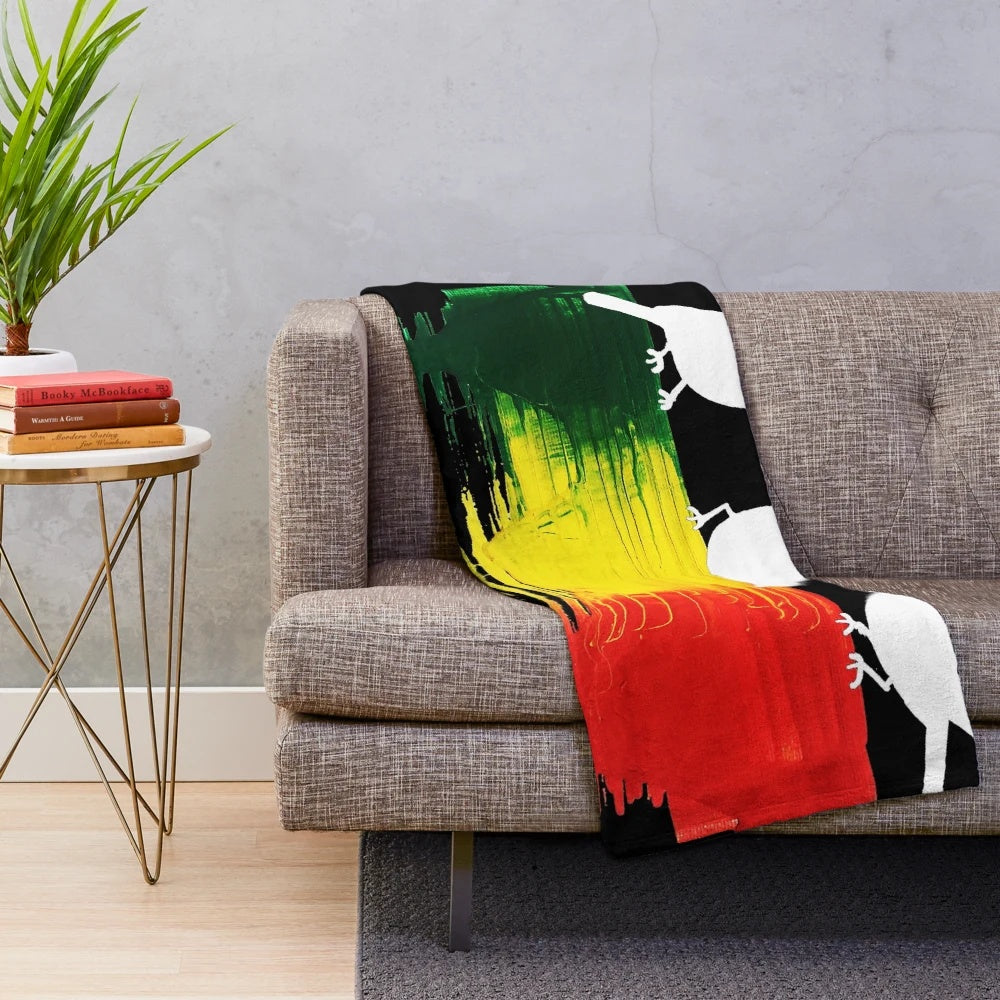 Plush blanket featuring three little birds in rasta colors of red, green, and gold