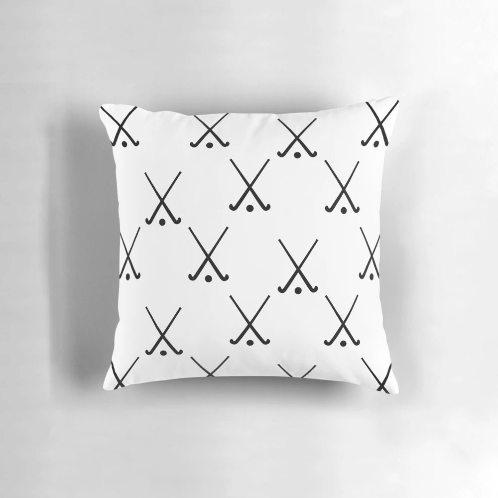 A plush field hockey-themed pillow featuring crossed hockey sticks against a green background.