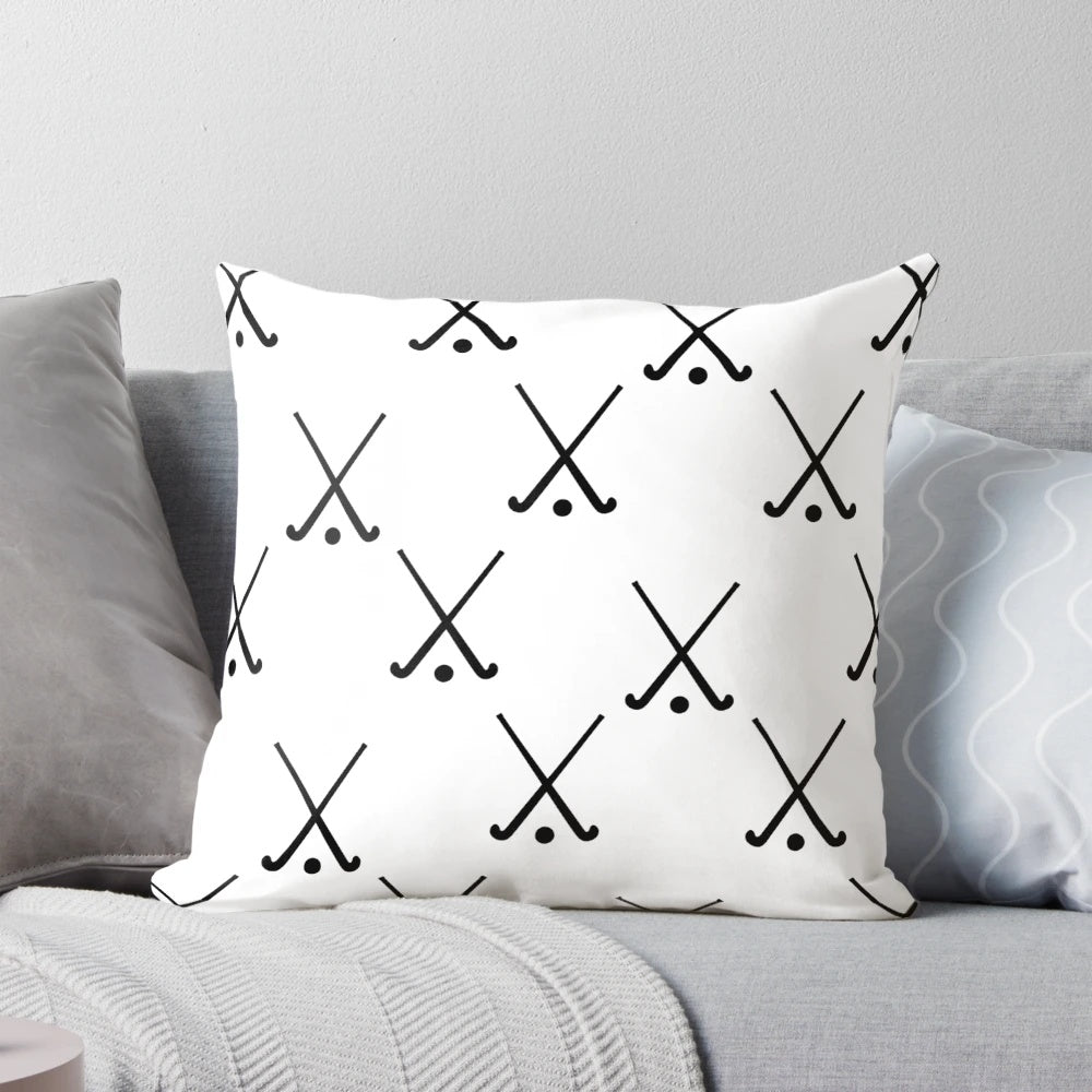 A plush field hockey-themed pillow featuring crossed hockey sticks against a green background.