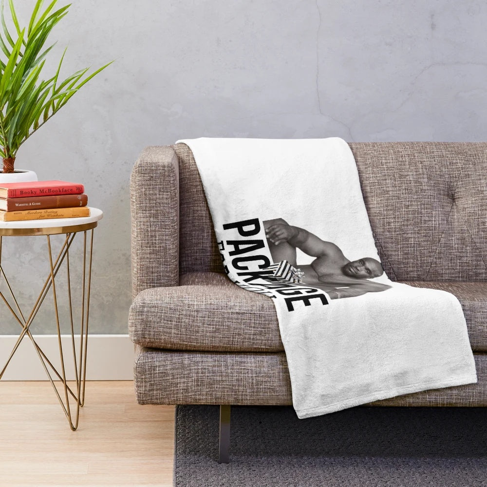 A person sitting on a bed, wrapped in a cozy plush blanket