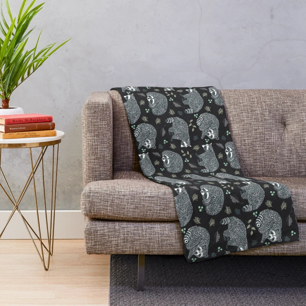 Soft and warm plush blanket featuring a repeating raccoon pattern design