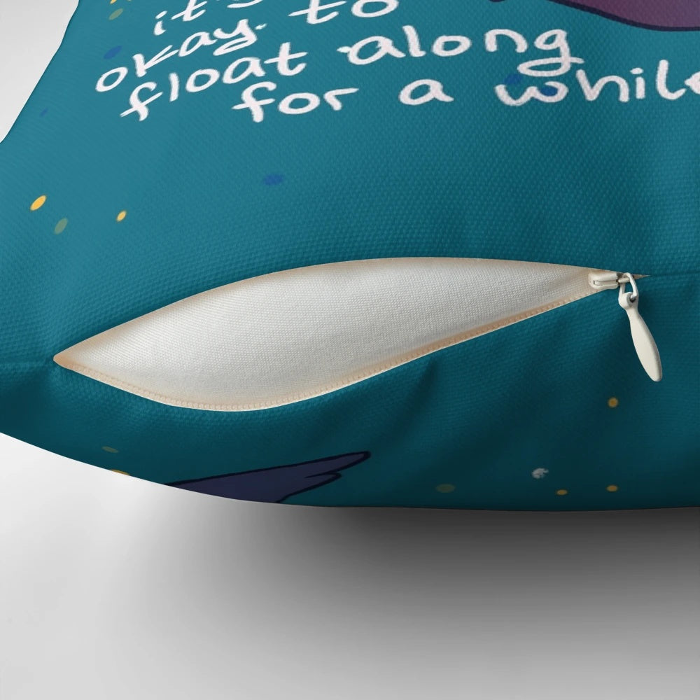 Soft, teal-colored pillow with a hand holding two otters floating on the water