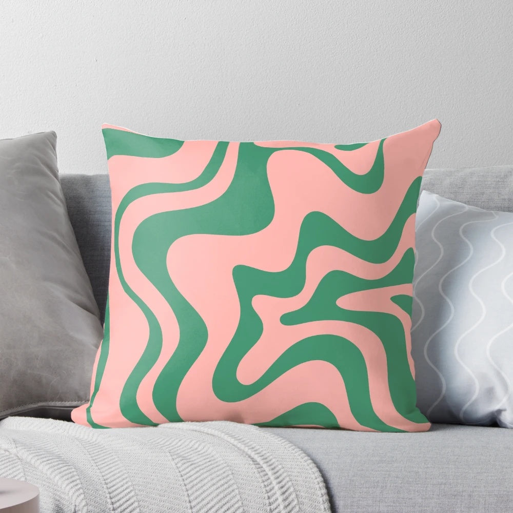A contemporary abstract pattern pillow in shades of pink and green, with a psychedelic, kaleidoscopic design.