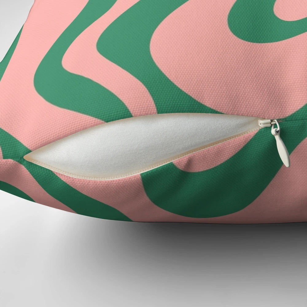 A contemporary abstract pattern pillow in shades of pink and green, with a psychedelic, kaleidoscopic design.