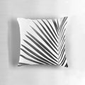 A modern black and white palm leaf design on a decorative throw pillow