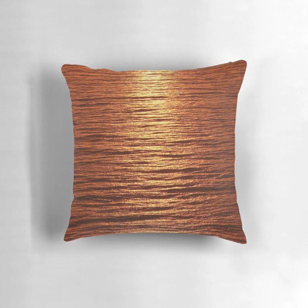 A copper-toned pillow with a serene seascape design, perfect for adding a touch of nature-inspired style to your home.