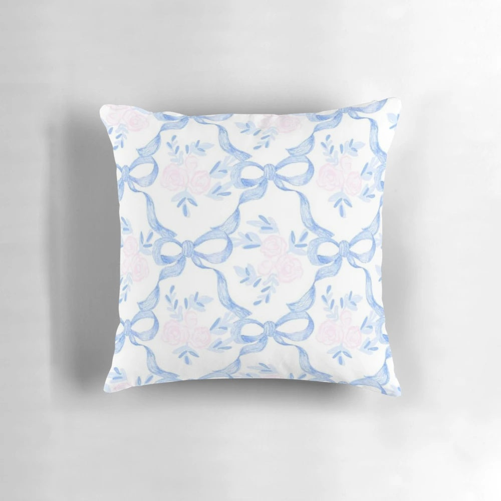 A pink and white pillow with a coquette balletcore pattern, featuring bows and ribbons for a soft, feminine touch.