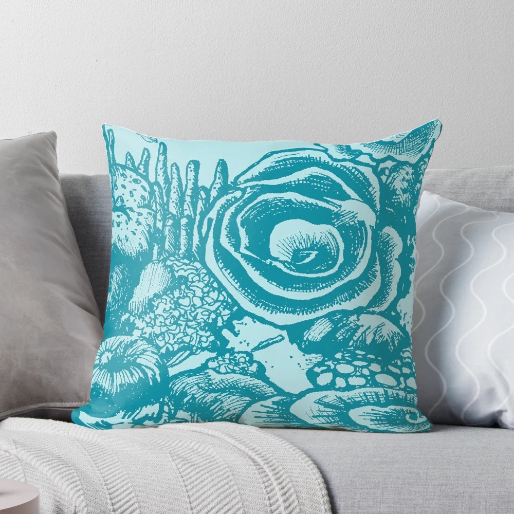 Green and blue colored pillow with a coral reef and ocean life design