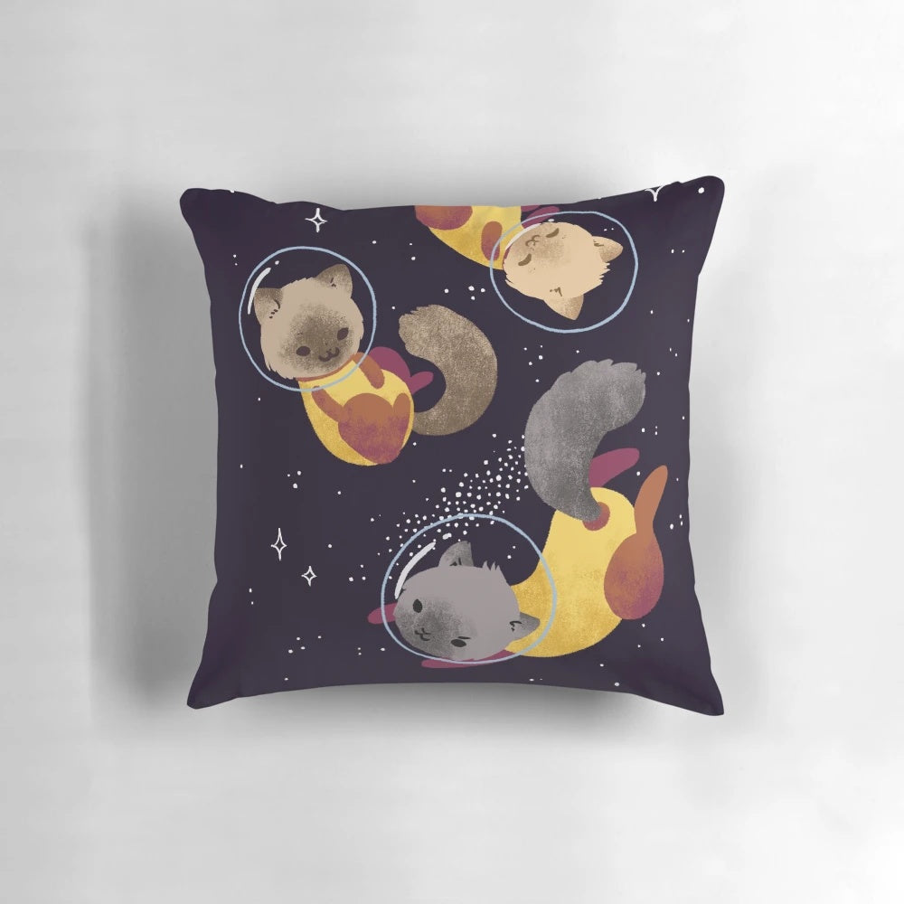 Colorful digital illustration of whimsical space cats floating among stars on a soft, plush pillow