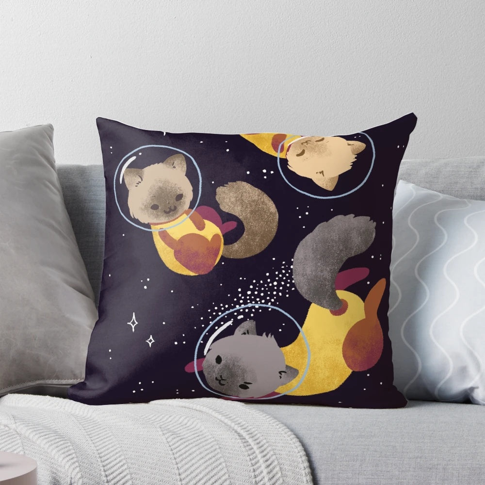 Colorful digital illustration of whimsical space cats floating among stars on a soft, plush pillow