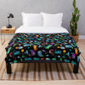 Watercolor dinosaur pattern on a plush galaxy-themed blanket