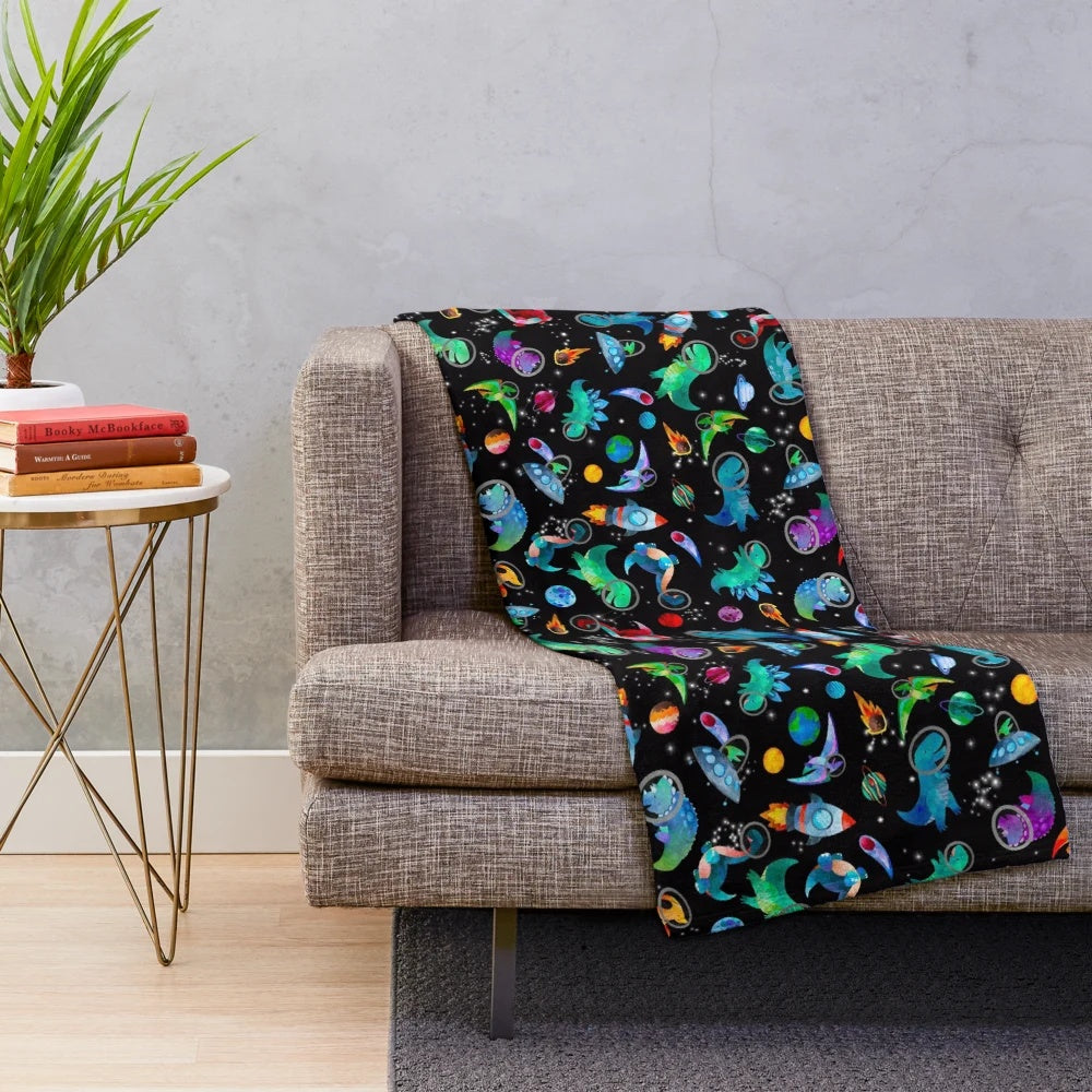 Watercolor dinosaur pattern on a plush galaxy-themed blanket