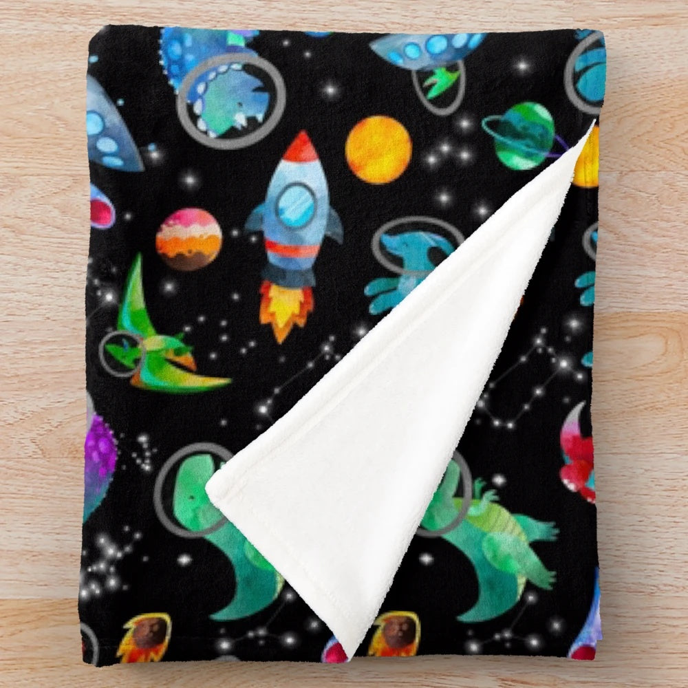 Watercolor dinosaur pattern on a plush galaxy-themed blanket