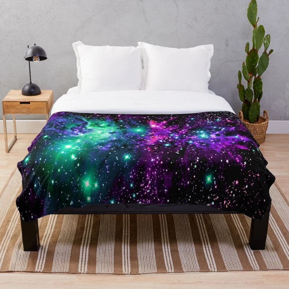 Cozy plush blanket featuring a vibrant cosmic nebula print in shades of mint, purple, and pink