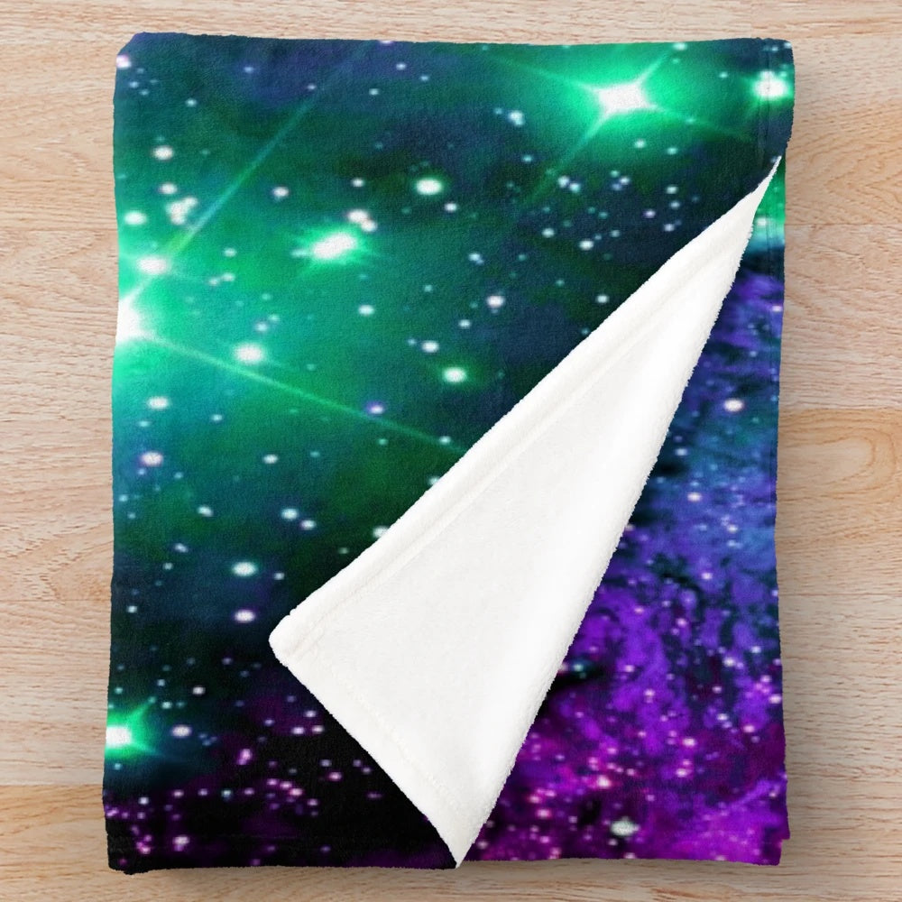 Cozy plush blanket featuring a vibrant cosmic nebula print in shades of mint, purple, and pink
