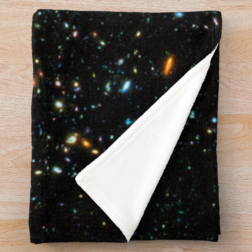 Hubble deep field inspired plush blanket with star field and galaxy design