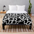 Cow print plush blanket with a soft, cozy texture
