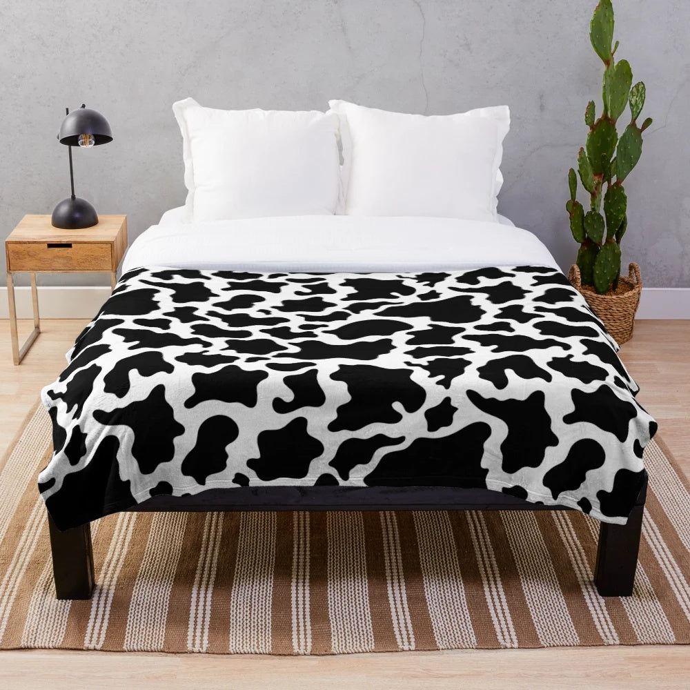 Cow print plush blanket with a soft, cozy texture