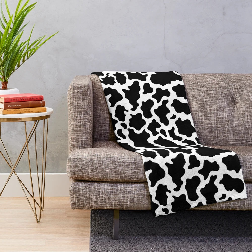 Cow print plush blanket with a soft, cozy texture