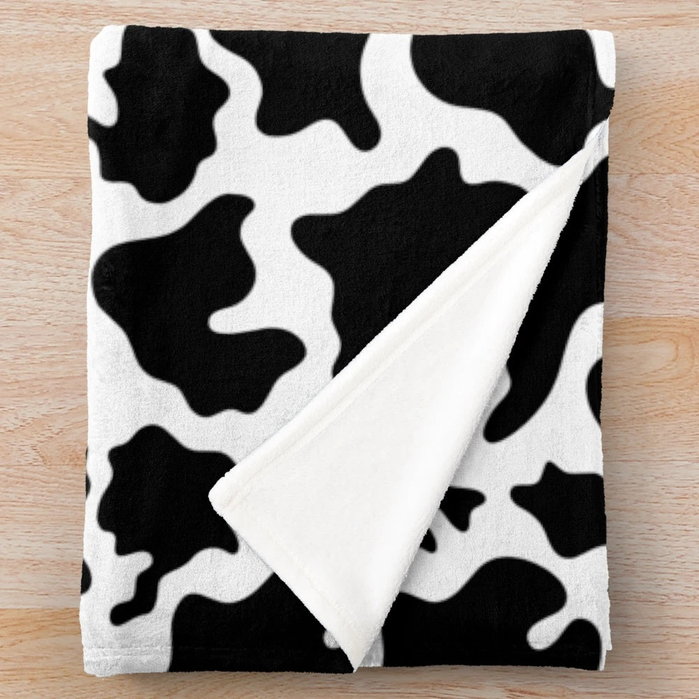 Cow print plush blanket with a soft, cozy texture