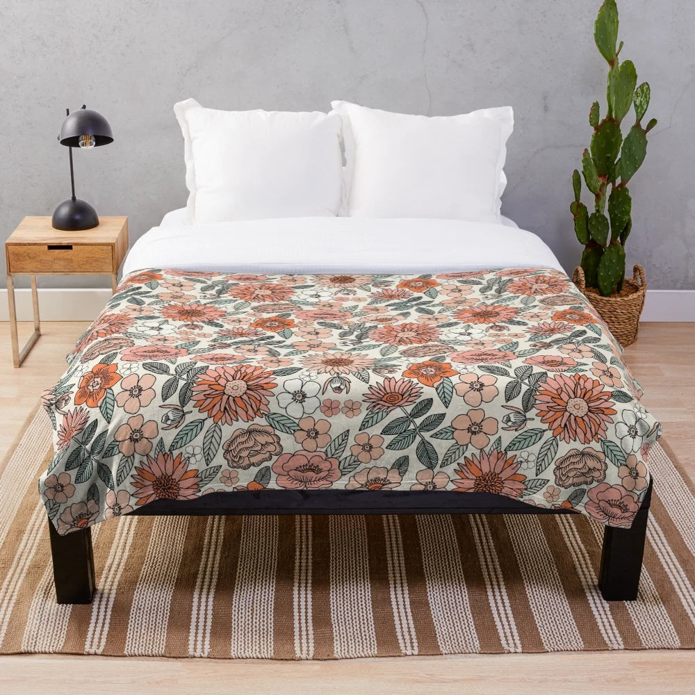 Soft and inviting plush blanket featuring a 70s inspired floral pattern in muted, earthy tones