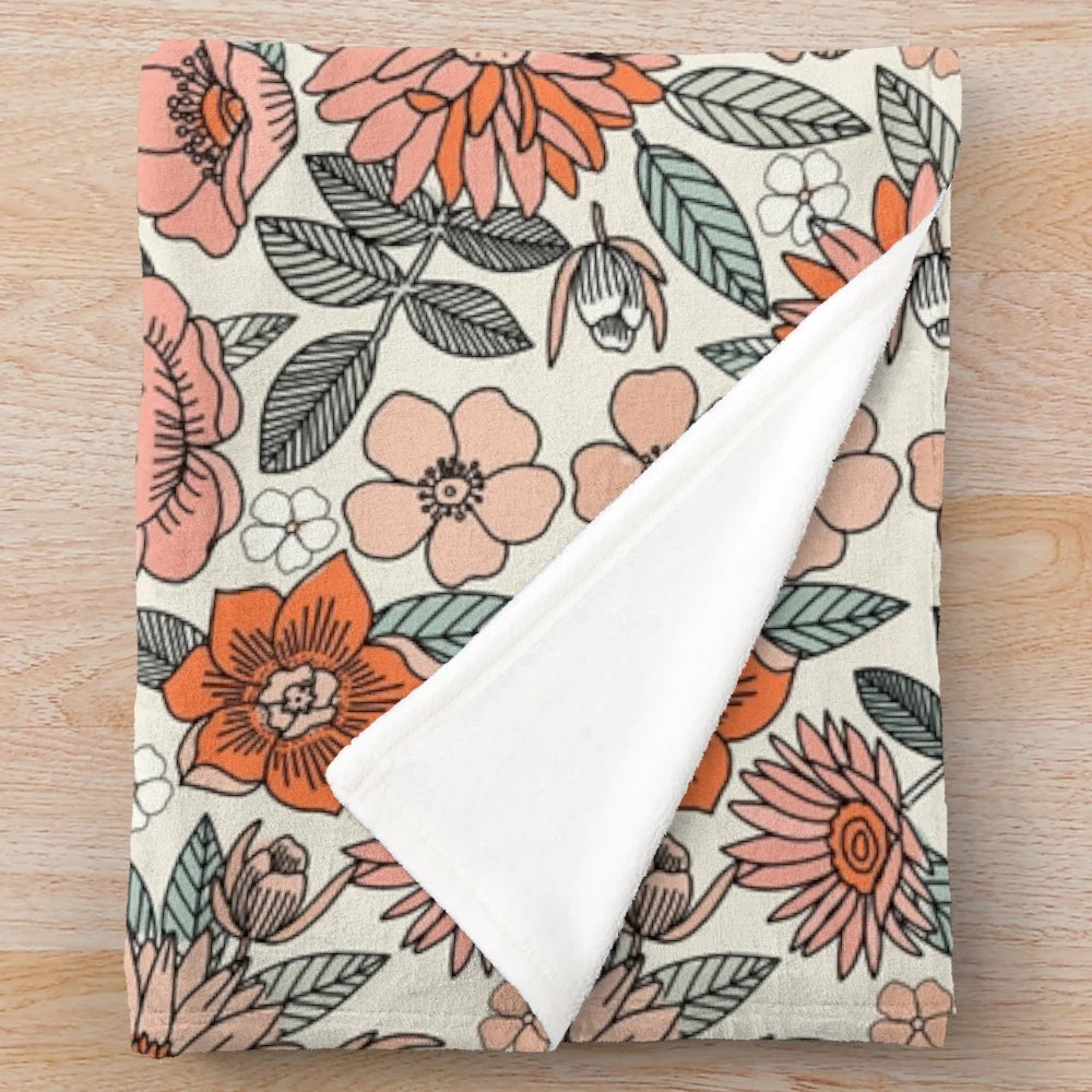 Soft and inviting plush blanket featuring a 70s inspired floral pattern in muted, earthy tones