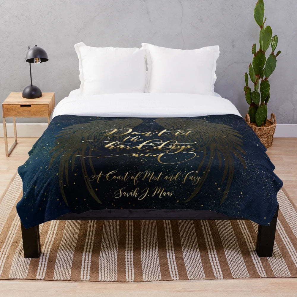 A cozy plush blanket featuring a watercolor and typography design inspired by the book A Court of Mist and Fury
