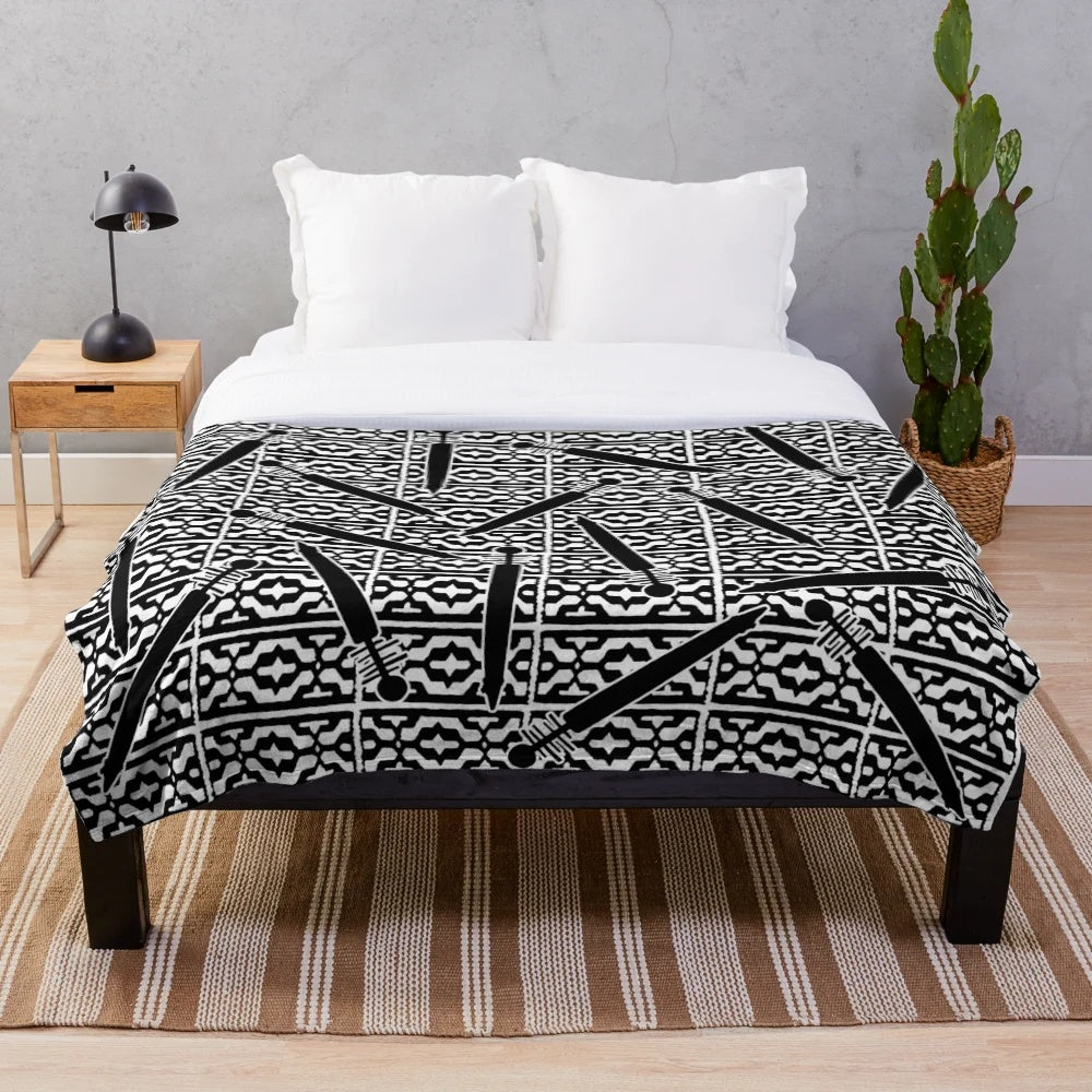 Plush blanket featuring a repeated Ainu-style pattern with scattered tonkari (traditional Japanese stringed instrument) silhouettes
