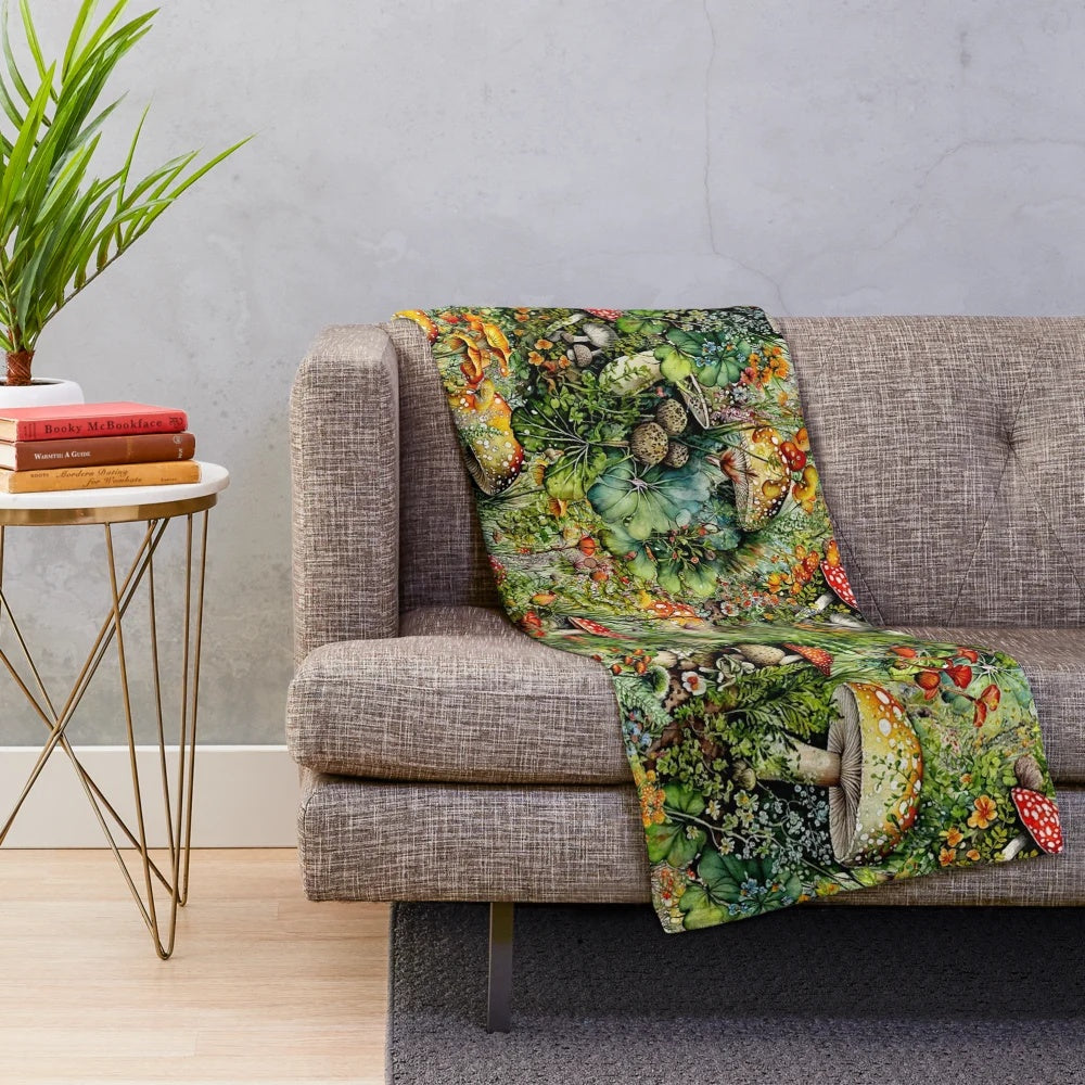 Amanita mushrooms and bright floral collage design on a plush, soft blanket