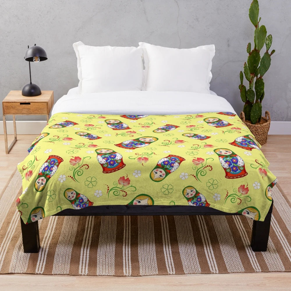 A colorful and adorable plush blanket featuring a whimsical Russian doll design.