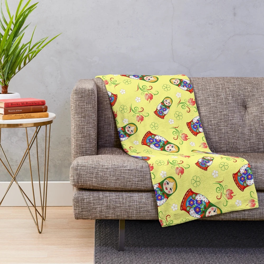 A colorful and adorable plush blanket featuring a whimsical Russian doll design.