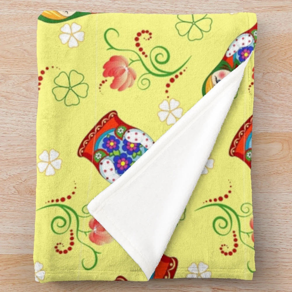 A colorful and adorable plush blanket featuring a whimsical Russian doll design.