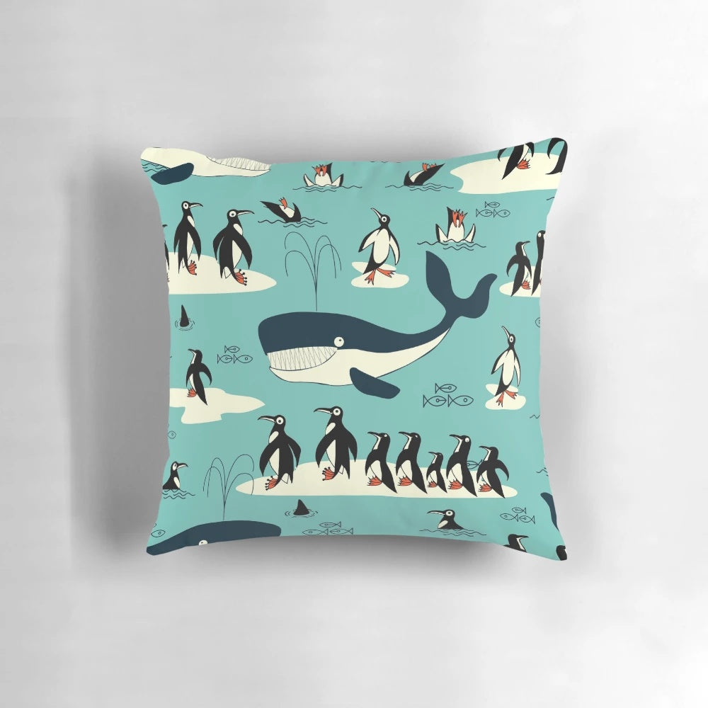 A decorative throw pillow featuring illustrations of whales, penguins, and other arctic animals.