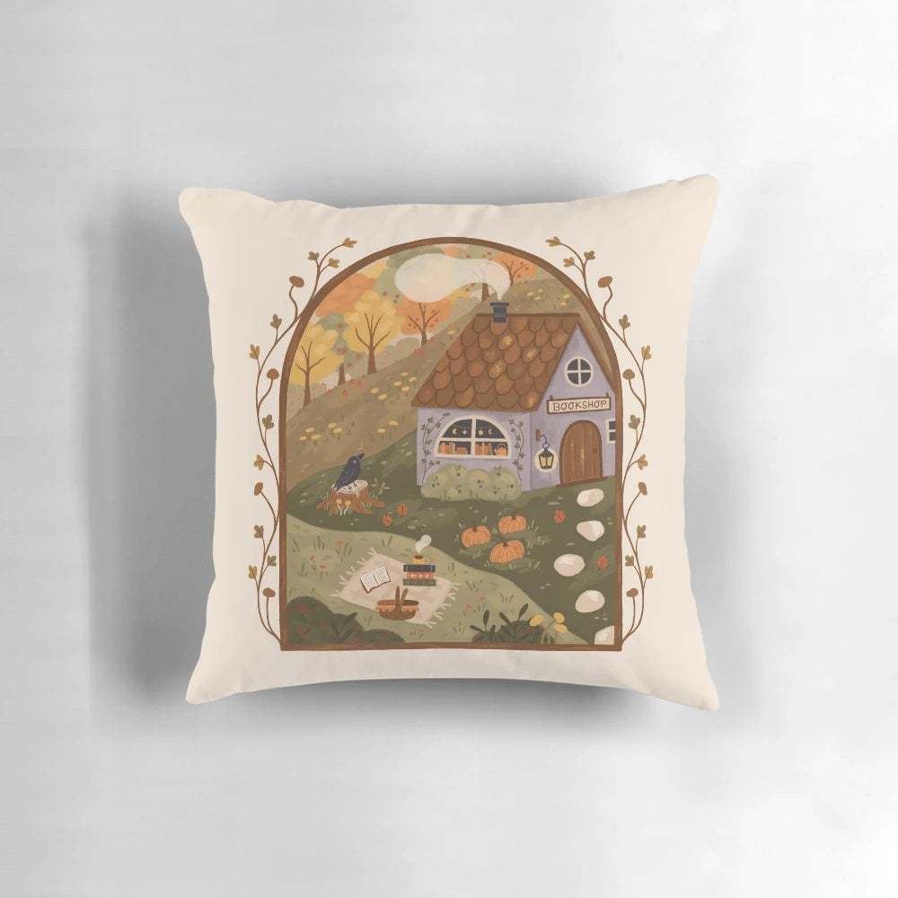 Autumn-themed throw pillow with books, pumpkins, and a cozy cottage design
