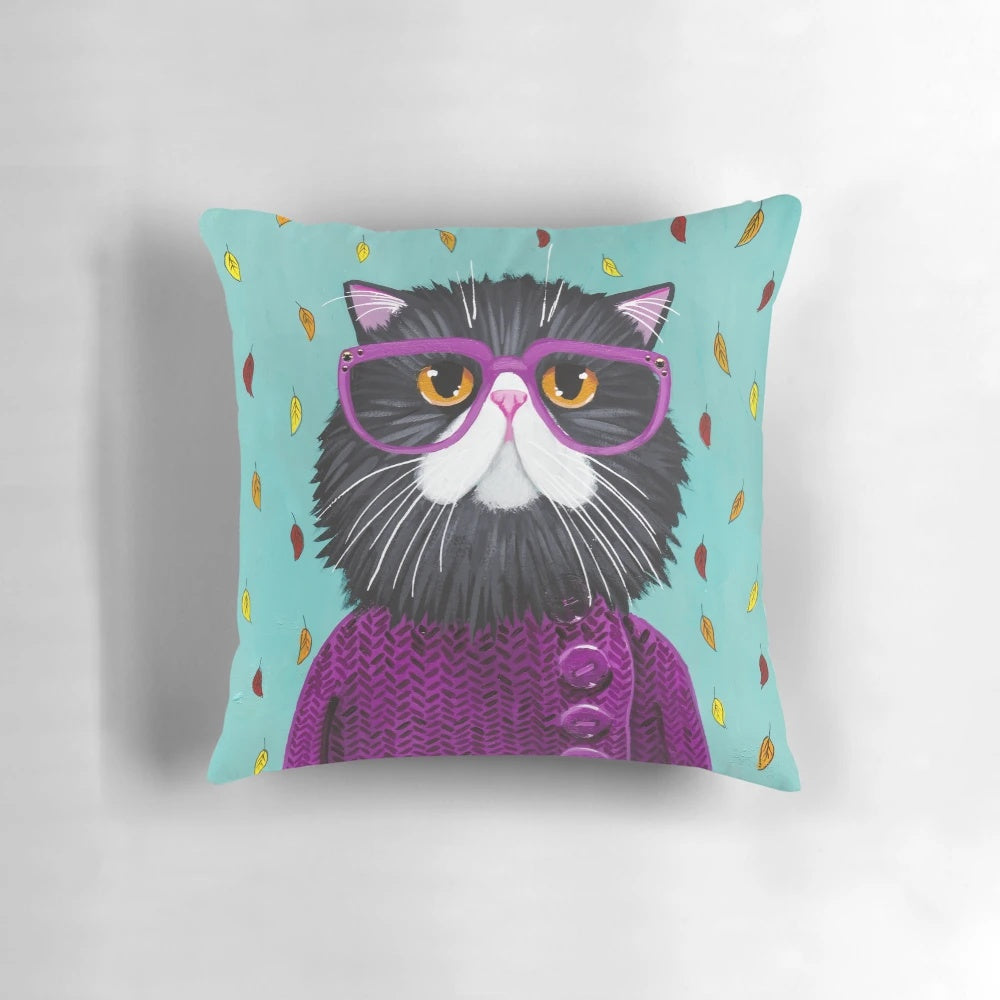 A cozy and plush pillow featuring a cute cat wearing glasses and surrounded by autumn leaves.