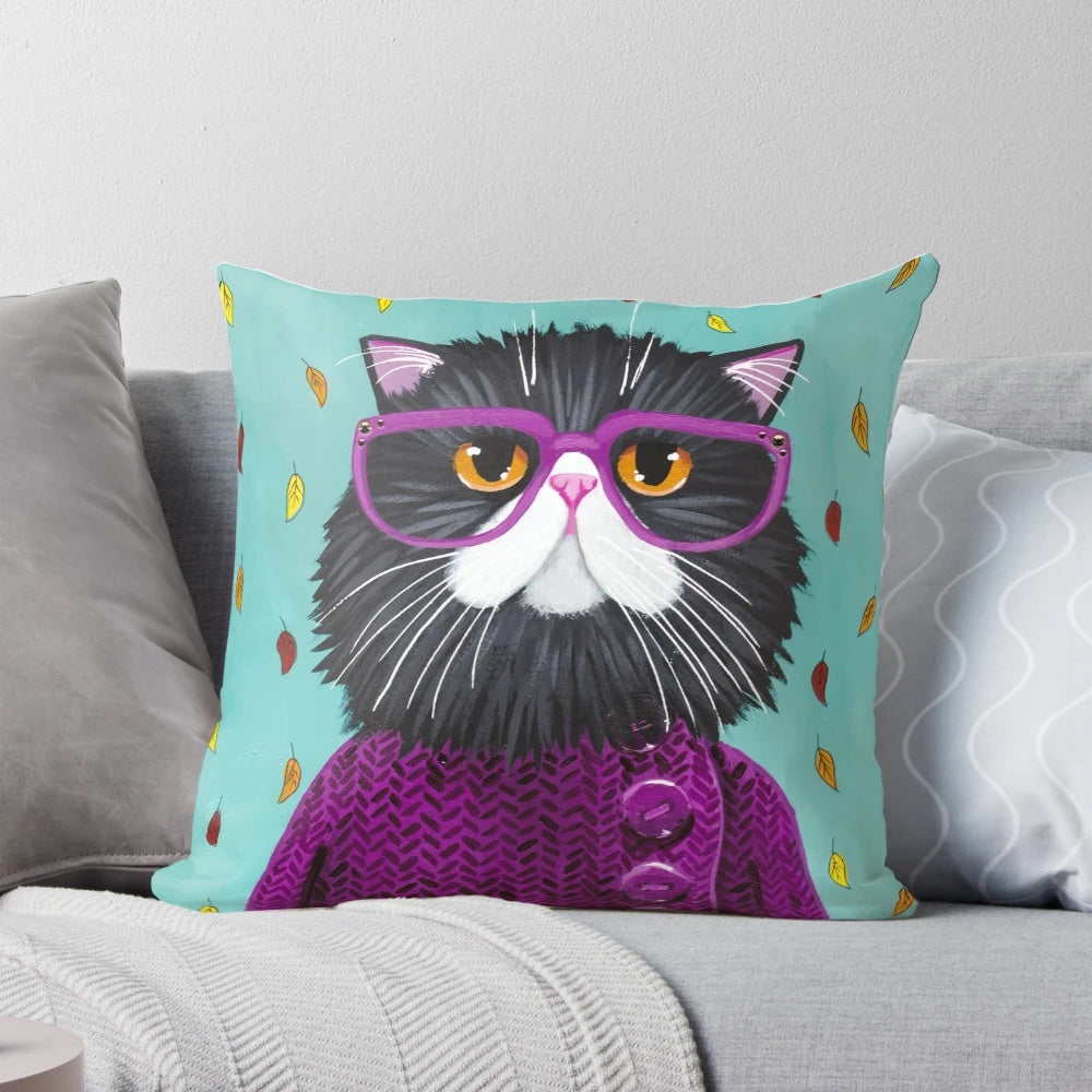 A cozy and plush pillow featuring a cute cat wearing glasses and surrounded by autumn leaves.