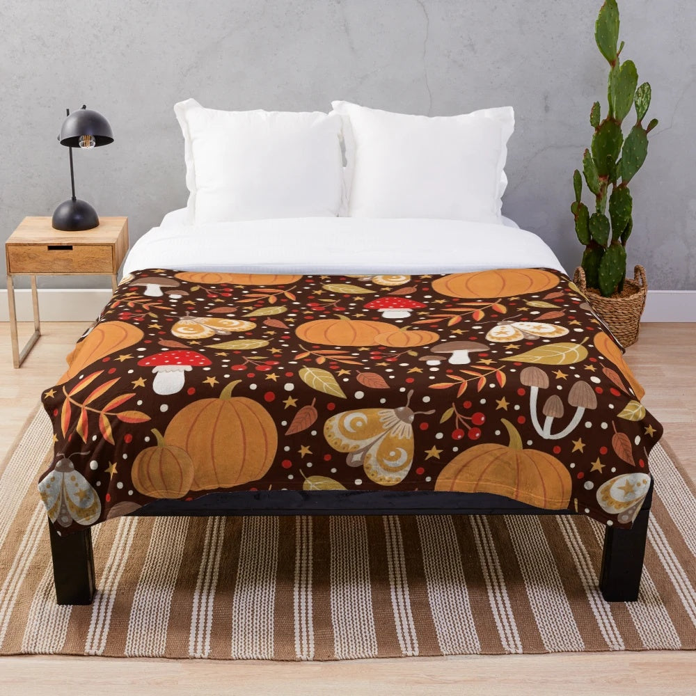 Autumn themed plush blanket with leaves, pumpkins, and other natural elements