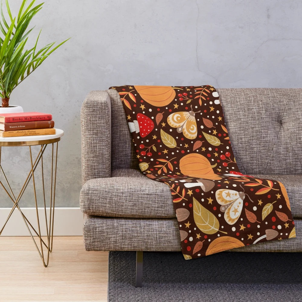 Autumn themed plush blanket with leaves, pumpkins, and other natural elements