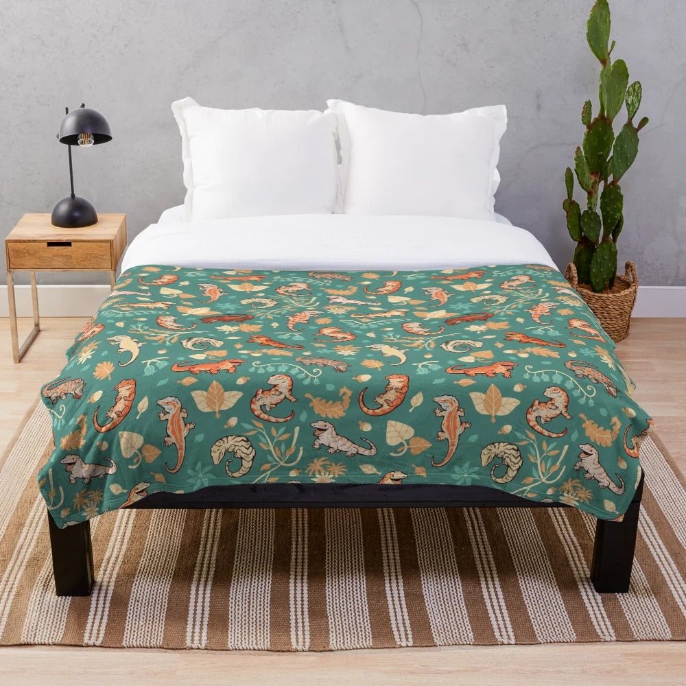Plush blanket featuring a green gecko or lizard pattern in autumn colors