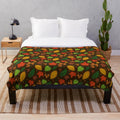 Plush blanket featuring a vibrant autumn leaves pattern in shades of orange, green, and yellow on a brown background