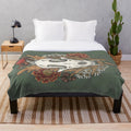 Plush blanket featuring autumn leaves and other witchy elements