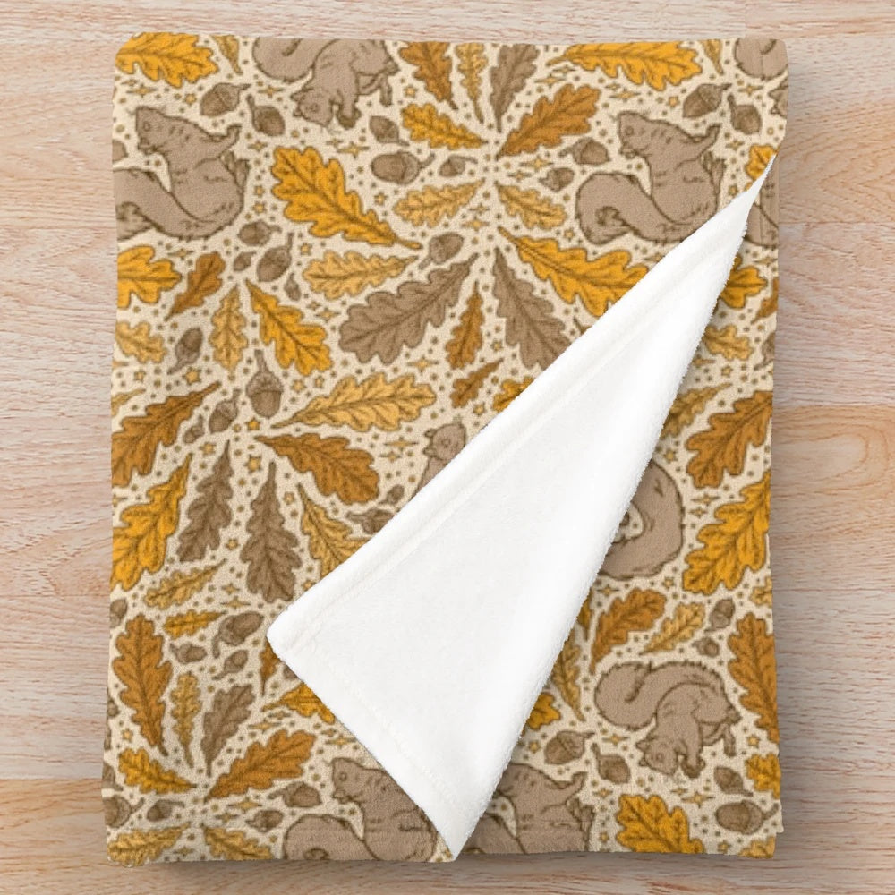 Plush blanket featuring a charming autumn nature design with oak trees and squirrels