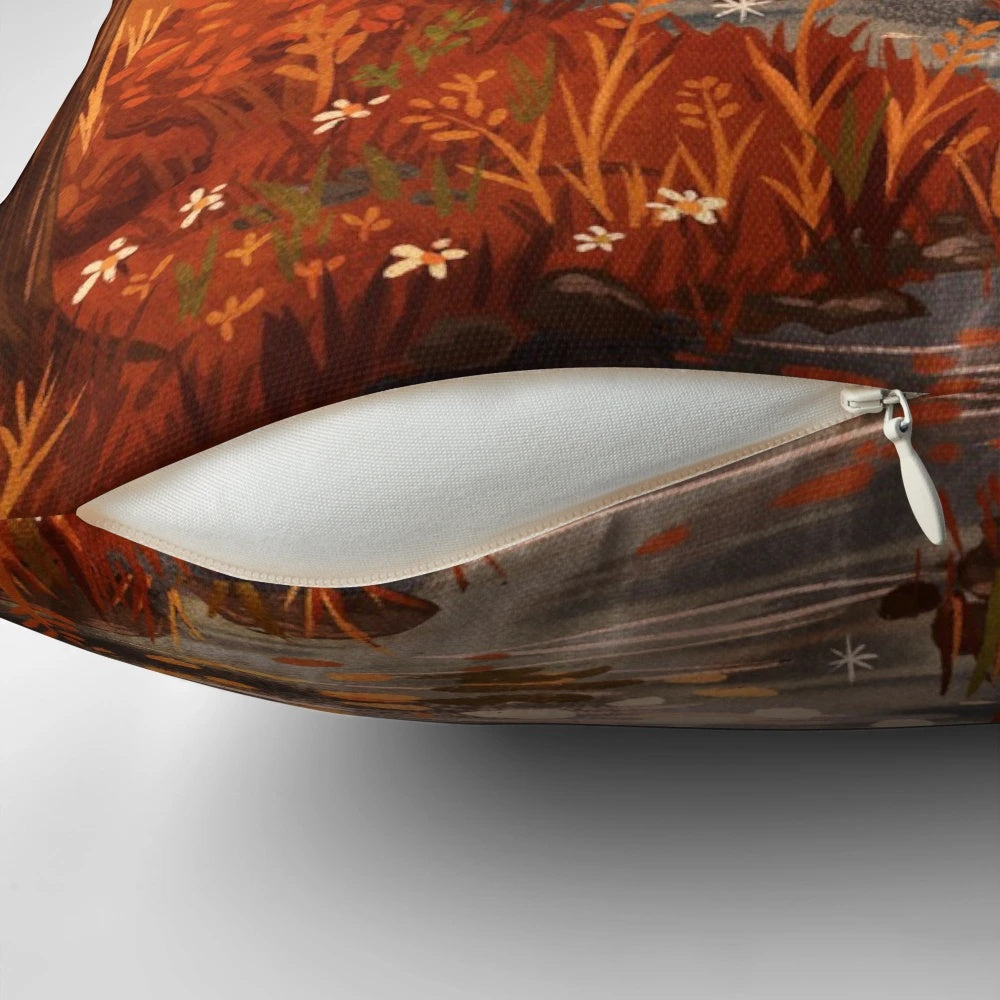 A plush, fall-themed pillow featuring a charming illustration of a frog sitting on a bridge surrounded by vibrant autumn leaves.