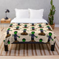 Plush green and orange blanket with monster and leaves design