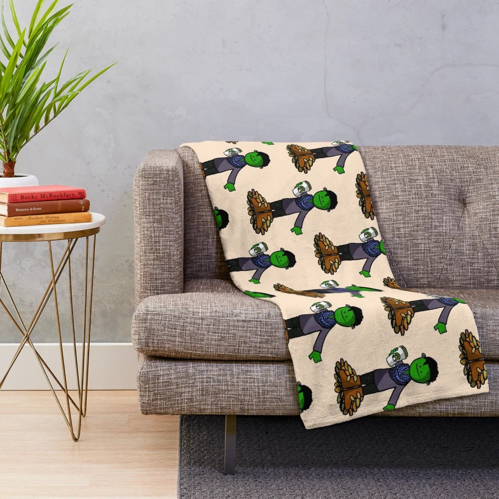 Plush green and orange blanket with monster and leaves design