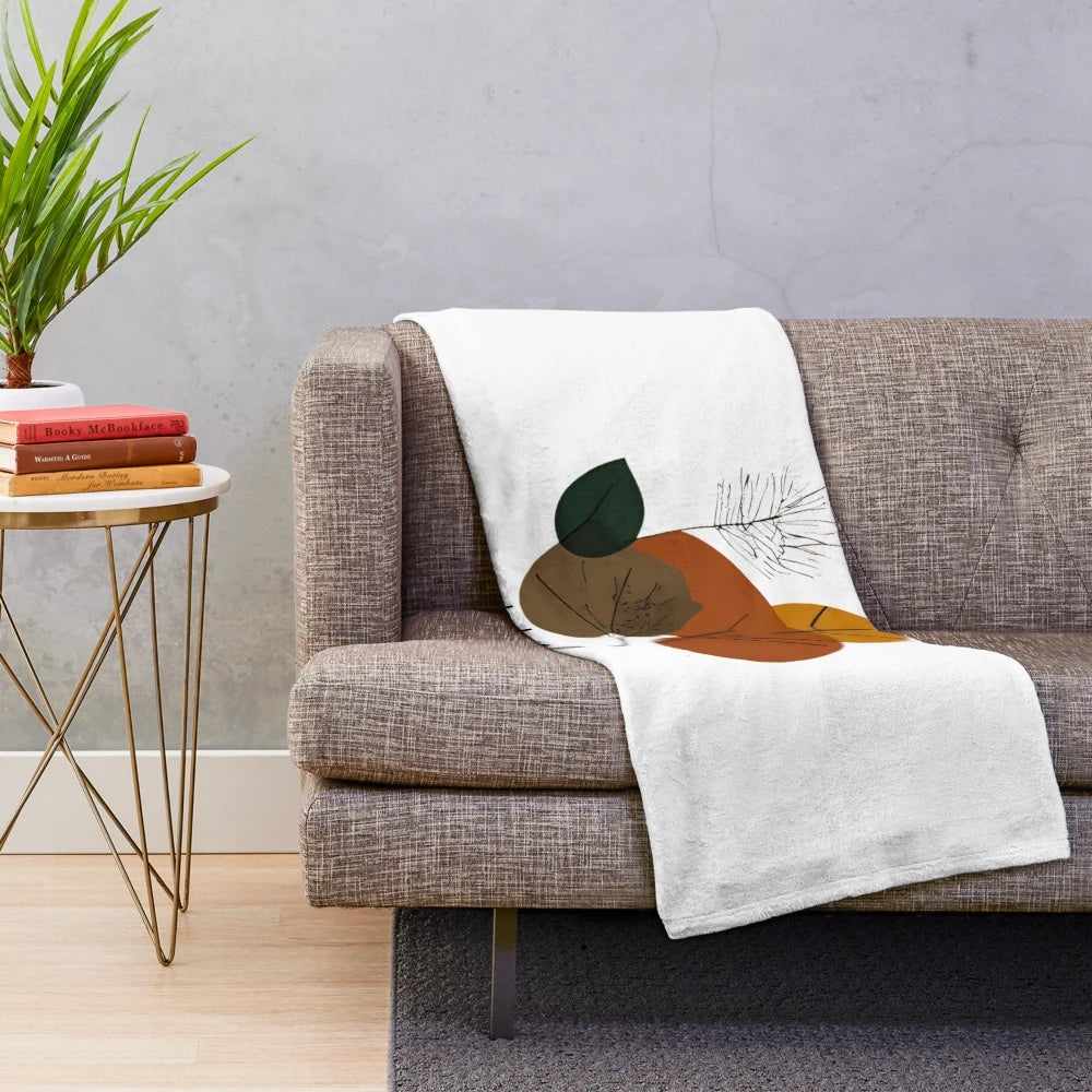 Plush blanket with minimalist autumn nature inspired design featuring leaves, trees, and floral patterns
