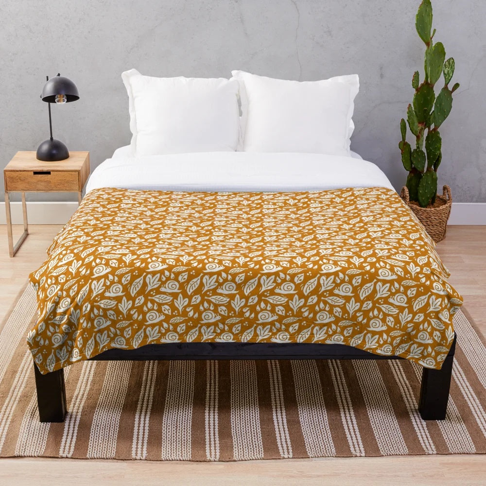 Cozy plush blanket with a nature-inspired snail and rain pattern for autumn decor