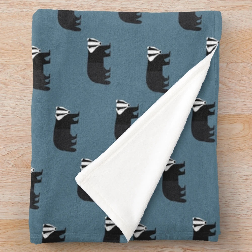 Soft and cozy plush blanket featuring a badger animal pattern in blue, black, and white.