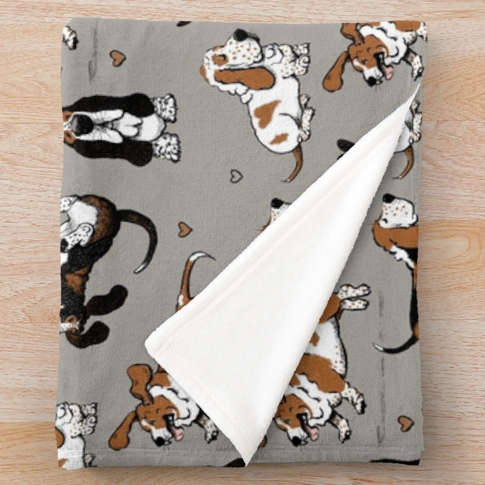 Basset hound puppies on a warm gray plush blanket