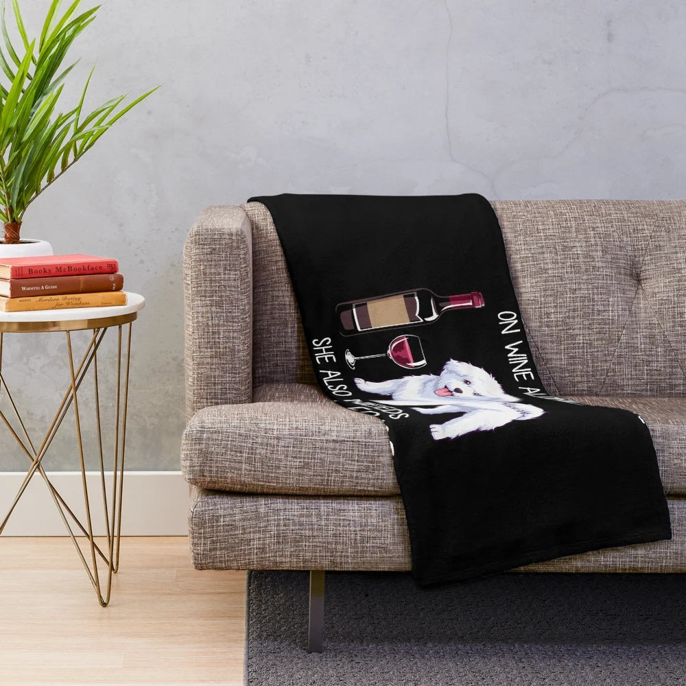 Bichon Frise dog on a plush blanket with a wine glass design